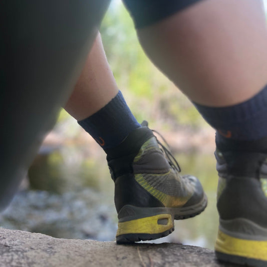 Close-up of hiking boots and socks on a natural outdoor setting